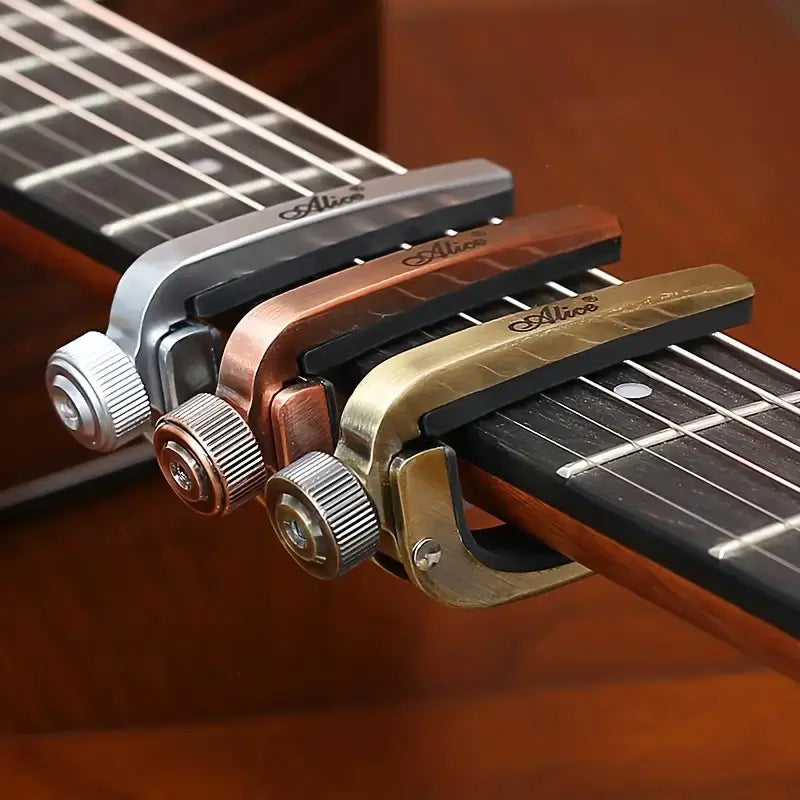 Guitar capo in four different colors on a guitar neck