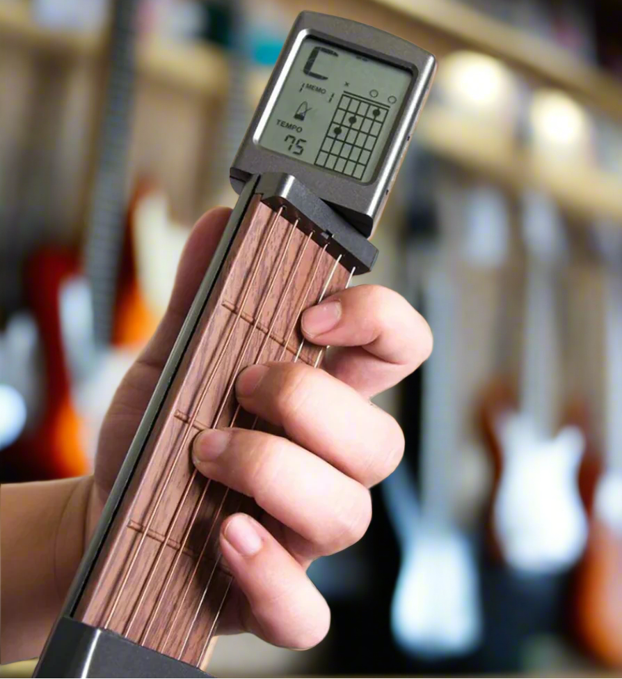 Hand holding a guitar trainer with blurred guitars in the background