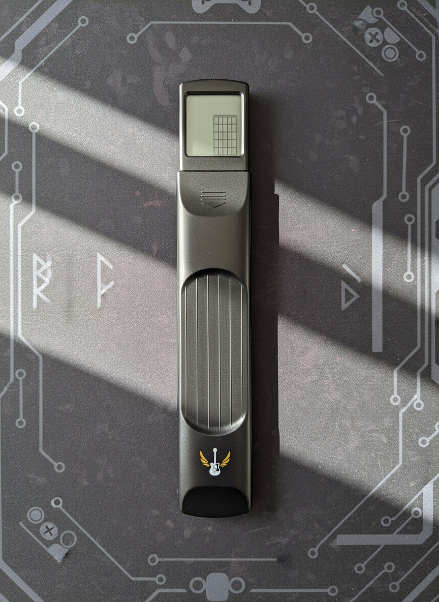 Portable guitar chord trainer with digital display on a table