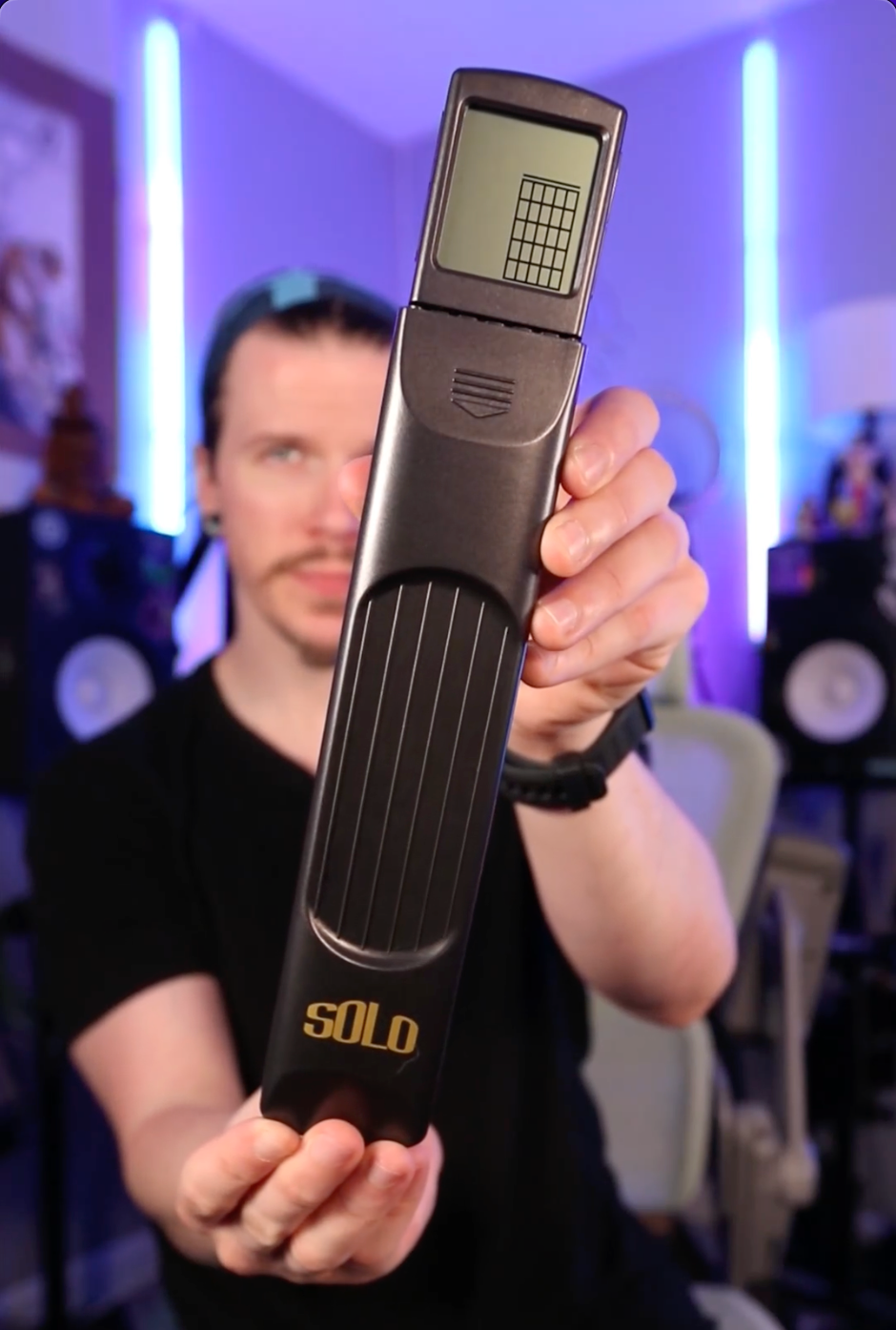 Person holding a portable guitar chord trainer.